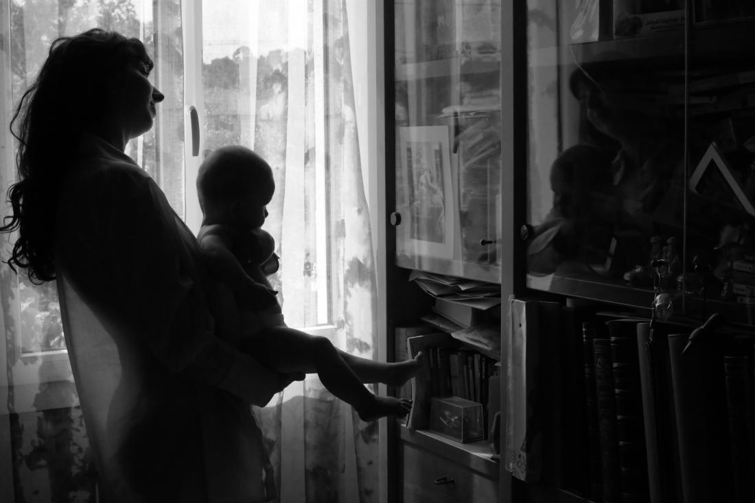 Silhouette d’une mère et de son bébé à la fenêtre