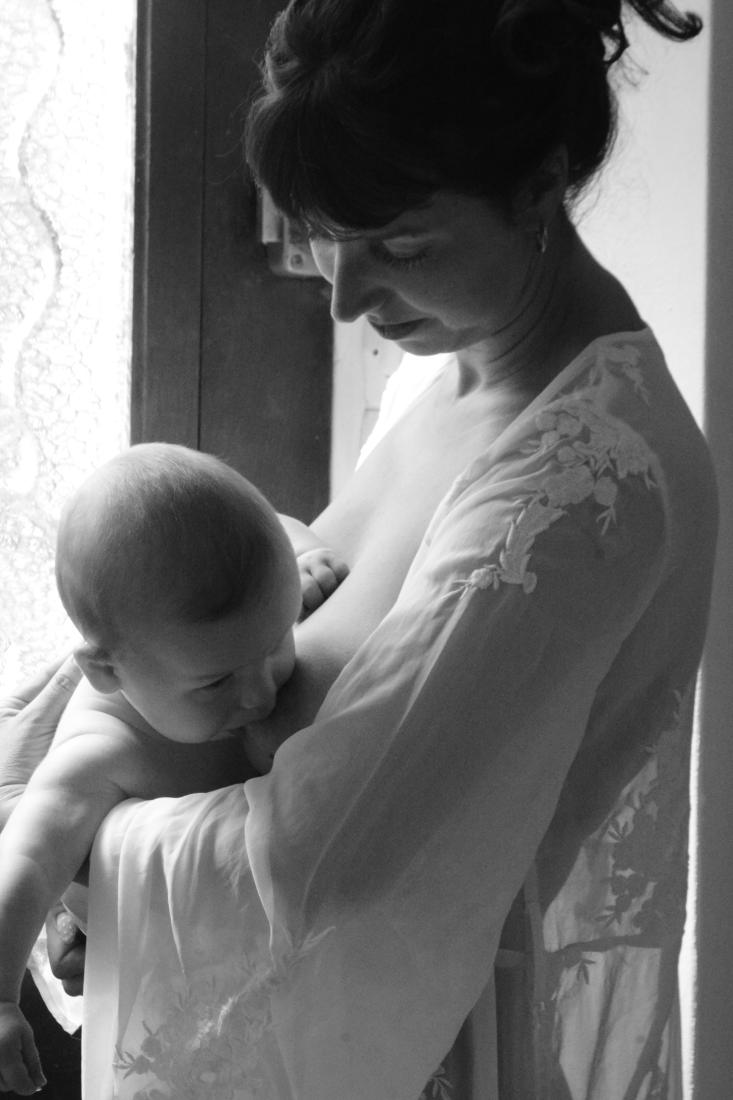 Mère et nouveau-né dans la lumière d’une fenêtre, noir et blanc